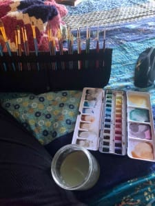 Stacey Couch art studio. Brushes, watercolor paints, and water jar in bed because of chronic illness.